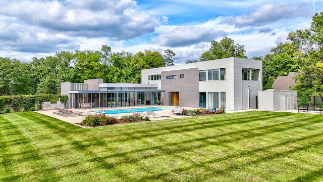 rear view of house with a lawn and a patio