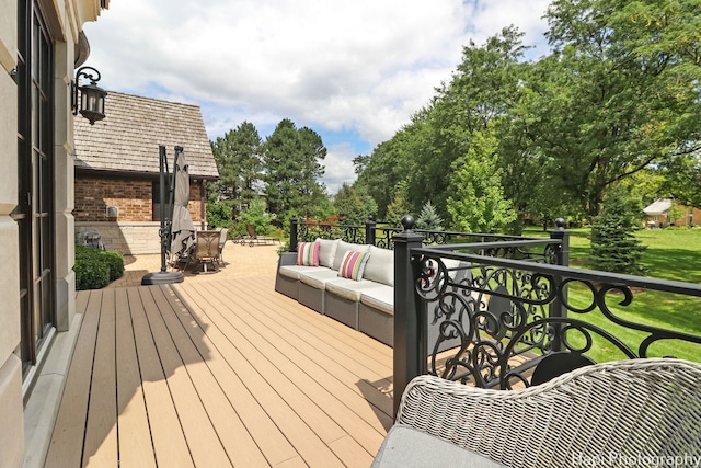 wooden terrace with a yard and an outdoor living space