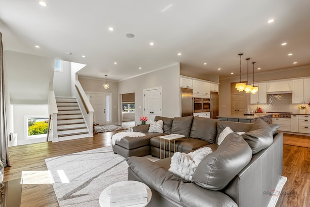 living room with light hardwood / wood-style floors and crown molding