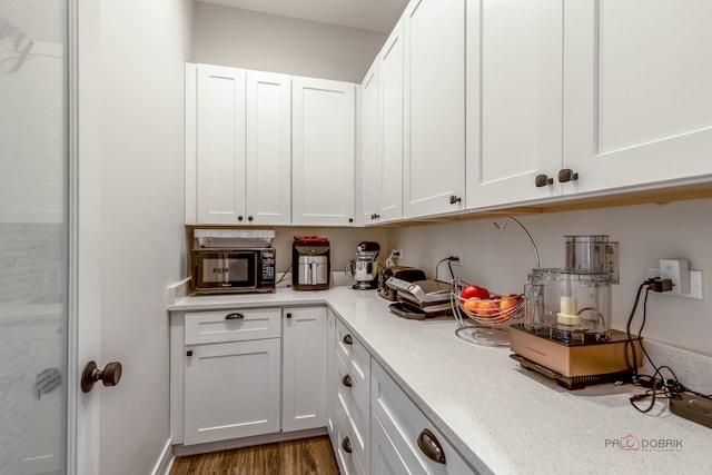 kitchen with white cabinetry and hardwood / wood-style floors