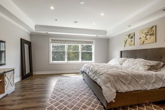 bedroom with dark hardwood / wood-style floors, crown molding, and a tray ceiling