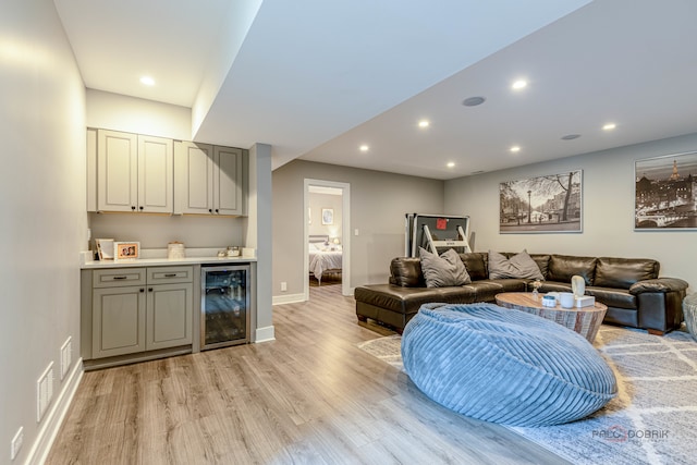 living room featuring wine cooler, indoor bar, and light wood-type flooring