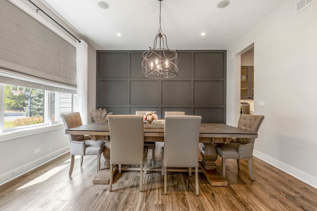 dining space with an inviting chandelier and light hardwood / wood-style flooring