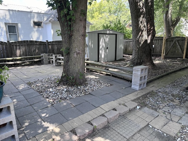 view of patio / terrace featuring a storage shed, a fenced backyard, and an outbuilding