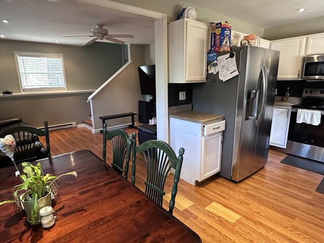 kitchen featuring backsplash, stainless steel appliances, ceiling fan, and light hardwood / wood-style floors