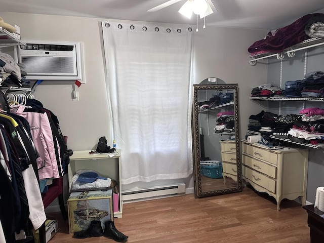 walk in closet with a baseboard radiator, ceiling fan, and wood finished floors