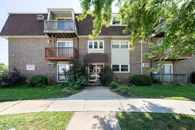 exterior space with a balcony and a front yard