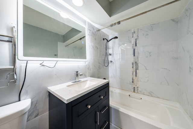 full bathroom featuring tile walls, toilet, vanity, and tiled shower / bath