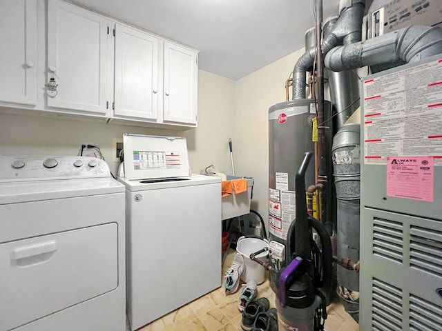 clothes washing area featuring gas water heater, cabinets, heating unit, and independent washer and dryer