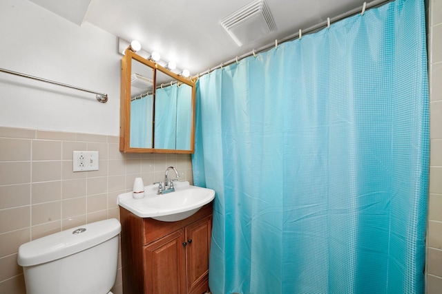 bathroom featuring tile walls, toilet, vanity, and decorative backsplash