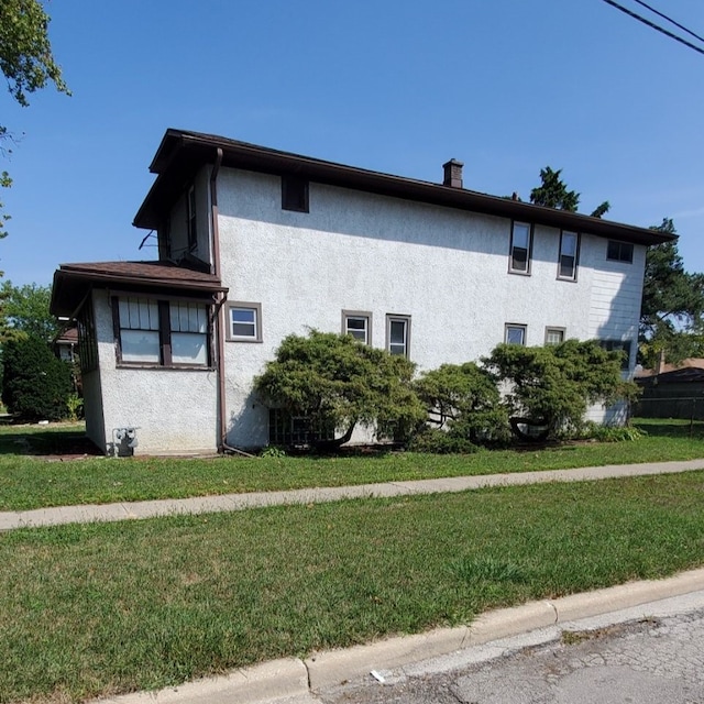 view of side of home with a yard and stucco siding