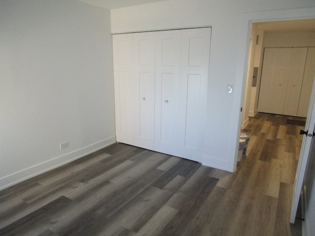 unfurnished bedroom with a closet and dark hardwood / wood-style flooring