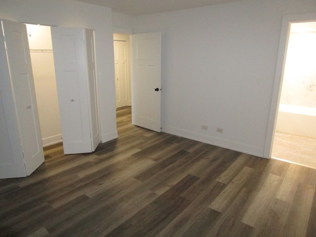 unfurnished bedroom with dark hardwood / wood-style floors and a closet