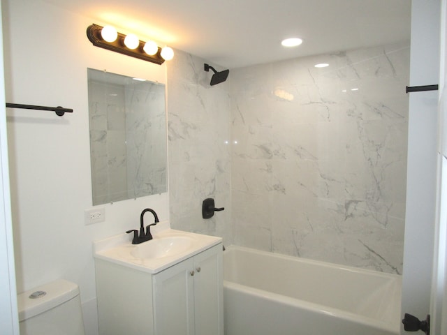 full bathroom with tiled shower / bath, vanity, and toilet