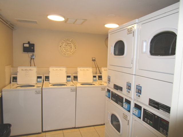 clothes washing area featuring stacked washer and clothes dryer, washer and clothes dryer, and light tile patterned floors