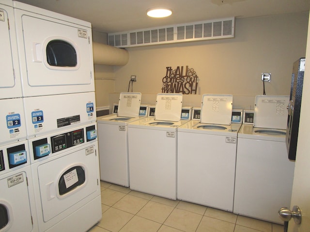 washroom featuring washer and dryer, stacked washer / drying machine, and light tile patterned floors