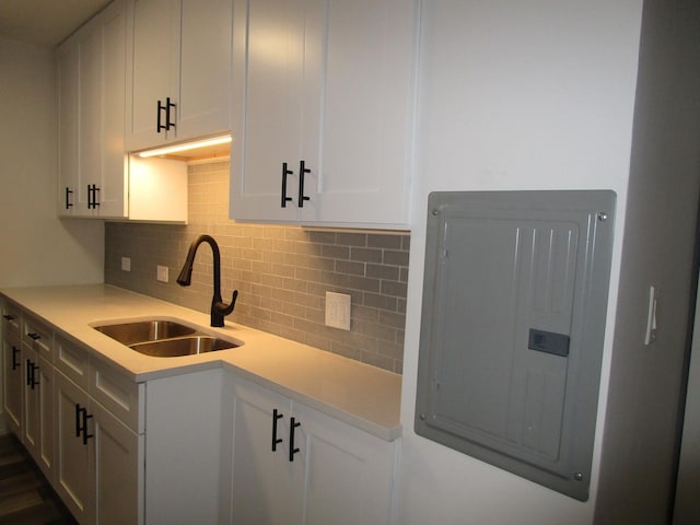 6730 S S Shore Dr Unit 1001, Chicago, IL 60649 - kitchen featuring backsplash, light countertops, a sink, electric panel, and white cabinetry