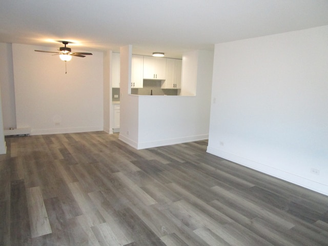 unfurnished living room featuring ceiling fan and dark hardwood / wood-style flooring