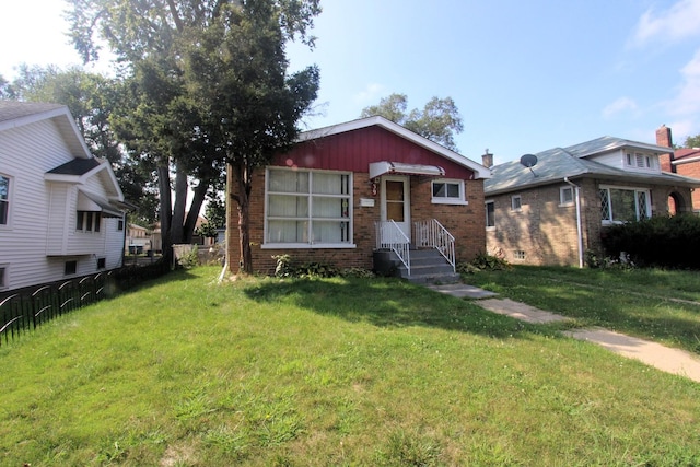 bungalow featuring brick siding and a front yard