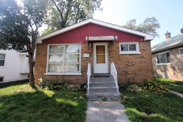 bungalow-style house featuring brick siding and fence