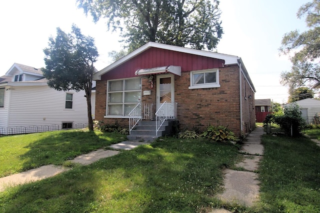 bungalow with brick siding, board and batten siding, and a front yard