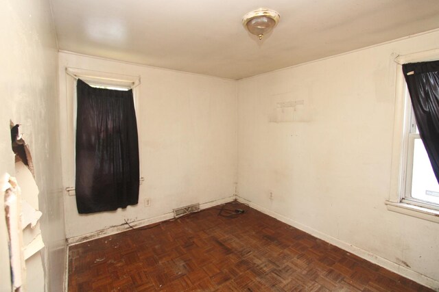 spare room featuring dark parquet flooring