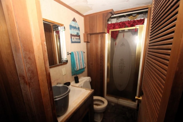 bathroom with toilet, a shower stall, crown molding, and vanity