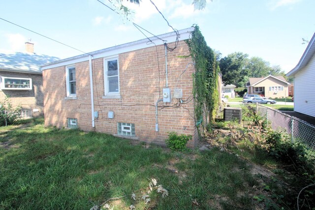 view of property exterior featuring central AC unit and a lawn