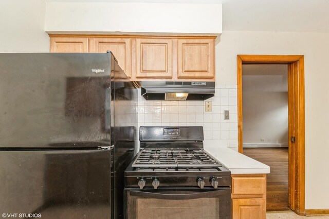 kitchen with light wood-type flooring, black appliances, light brown cabinetry, baseboard heating, and decorative backsplash