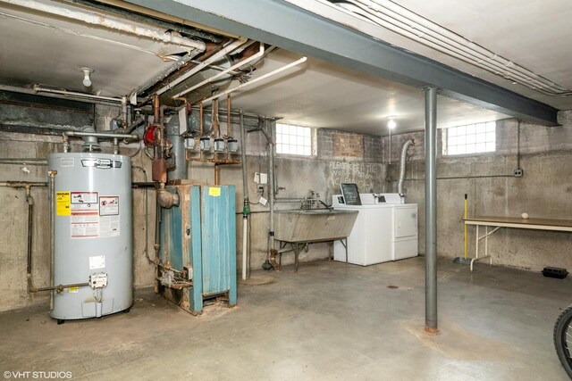 basement featuring gas water heater, washing machine and dryer, and sink