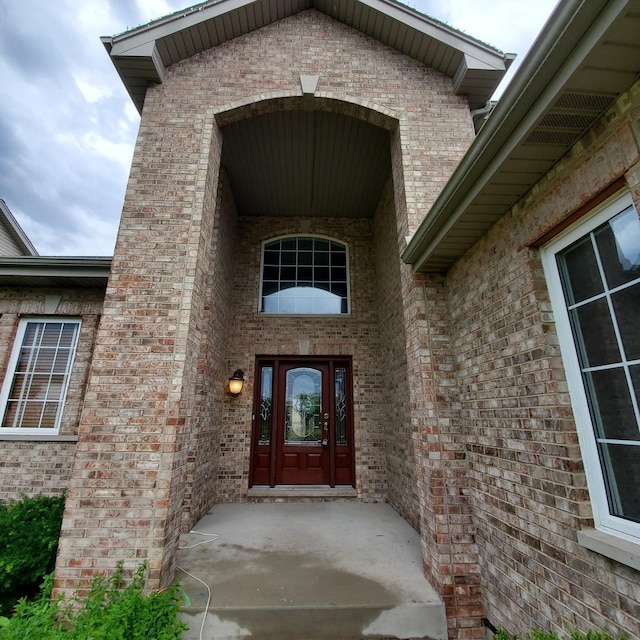 doorway to property featuring brick siding