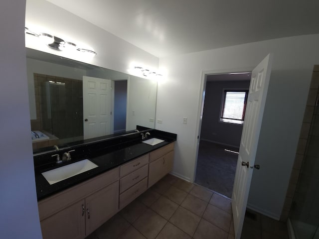 full bathroom featuring tile patterned flooring, a sink, a tile shower, and double vanity