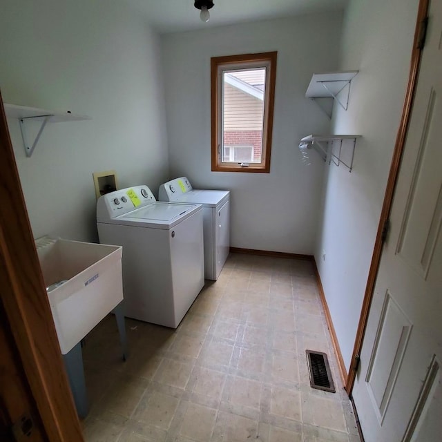 washroom featuring laundry area, baseboards, visible vents, washer and clothes dryer, and light floors