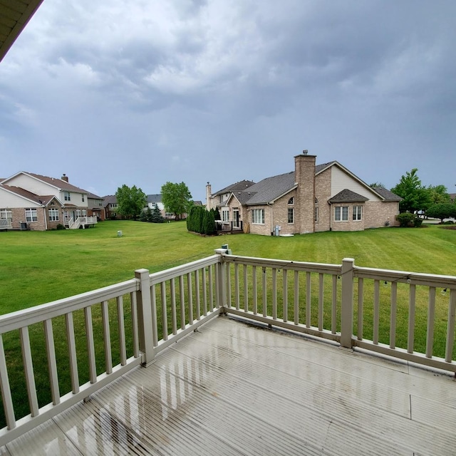 wooden deck with a lawn and a residential view