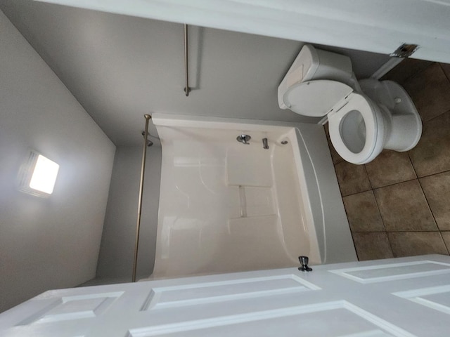 bathroom featuring toilet, tile patterned flooring, and walk in shower