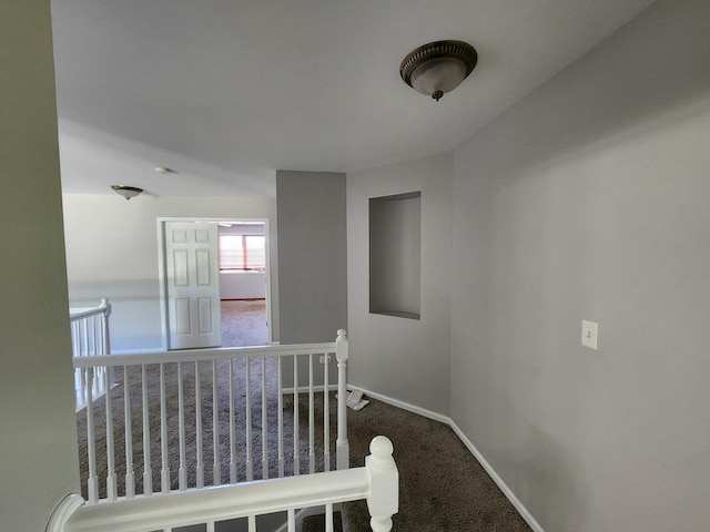 hallway with carpet flooring and baseboards