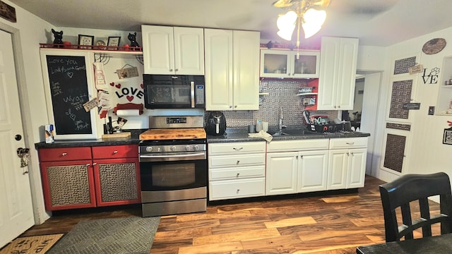 kitchen featuring tasteful backsplash, sink, stainless steel stove, white cabinets, and dark wood-type flooring