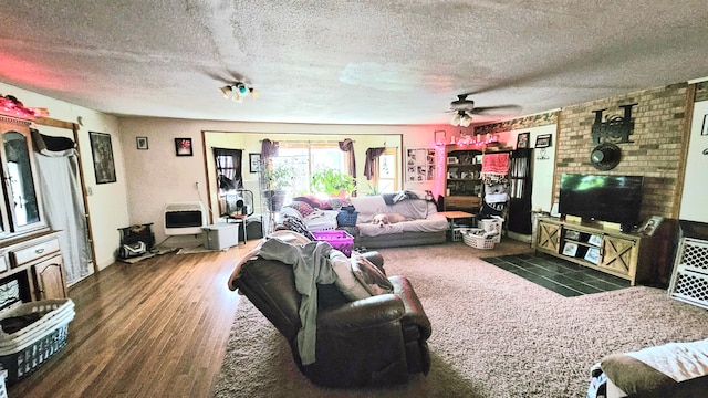 living room featuring dark wood-type flooring, a textured ceiling, and ceiling fan