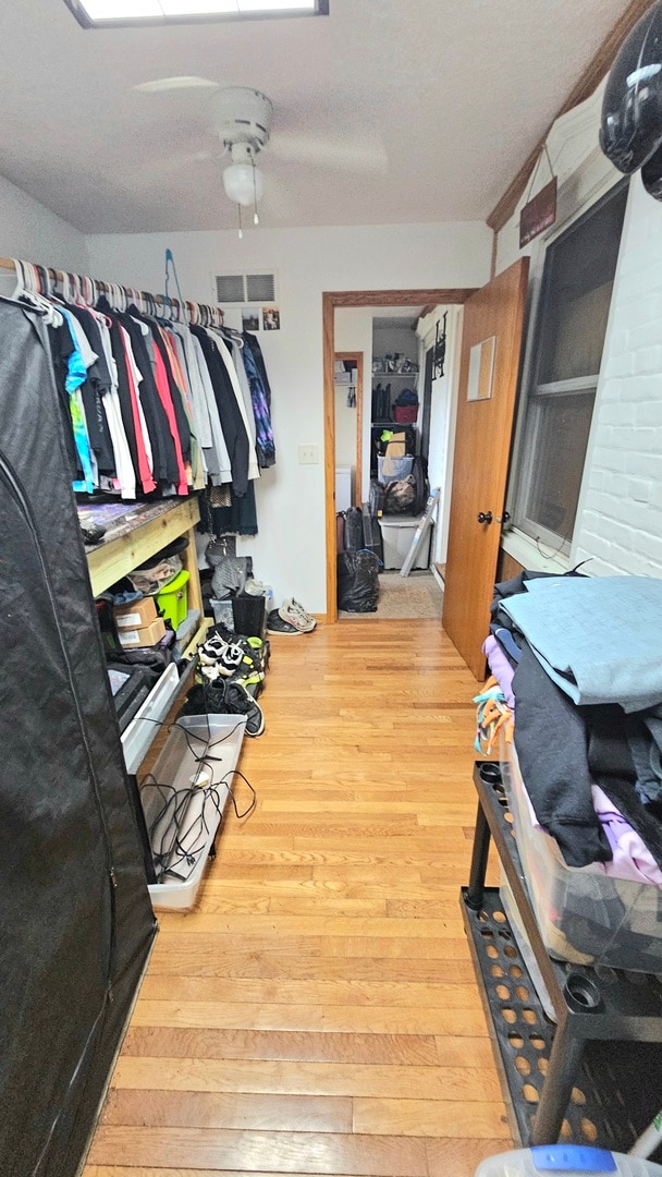 walk in closet featuring hardwood / wood-style flooring and ceiling fan