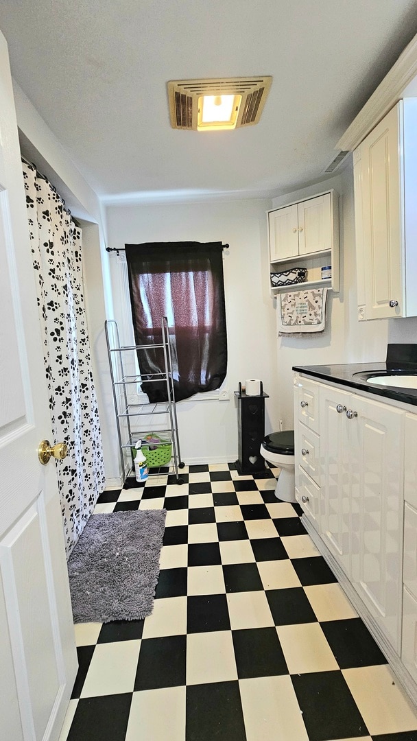 interior space with white cabinetry and sink