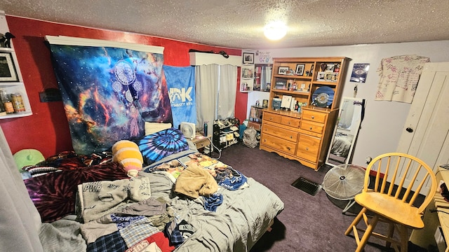 bedroom with dark carpet and a textured ceiling