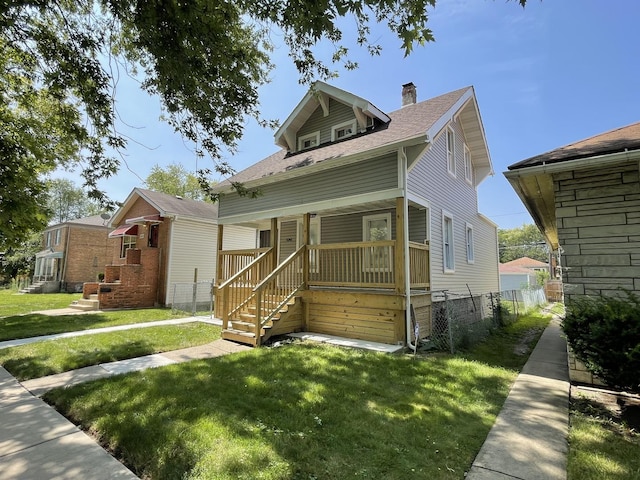 bungalow-style house with fence, roof with shingles, a porch, a chimney, and a front lawn