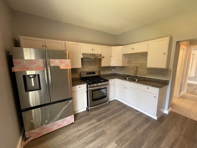 kitchen featuring dark hardwood / wood-style flooring, backsplash, stainless steel appliances, sink, and white cabinets