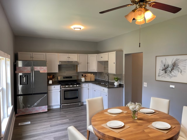 kitchen featuring dark hardwood / wood-style floors, tasteful backsplash, stainless steel appliances, sink, and ceiling fan