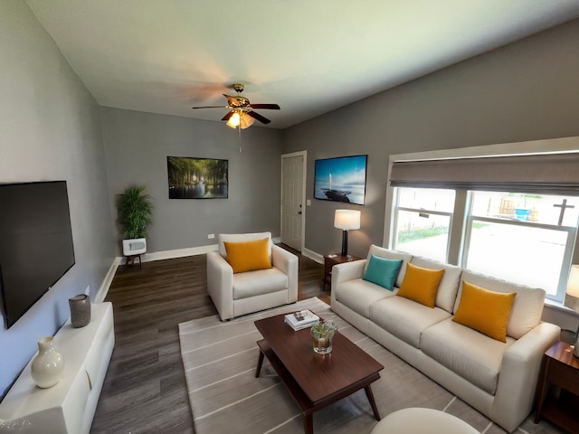 living room with ceiling fan, baseboards, and wood finished floors