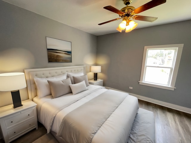 bedroom featuring a ceiling fan, baseboards, and dark wood-style flooring