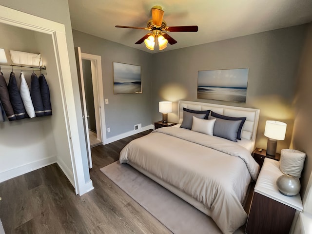 bedroom with ceiling fan, dark hardwood / wood-style floors, and a closet