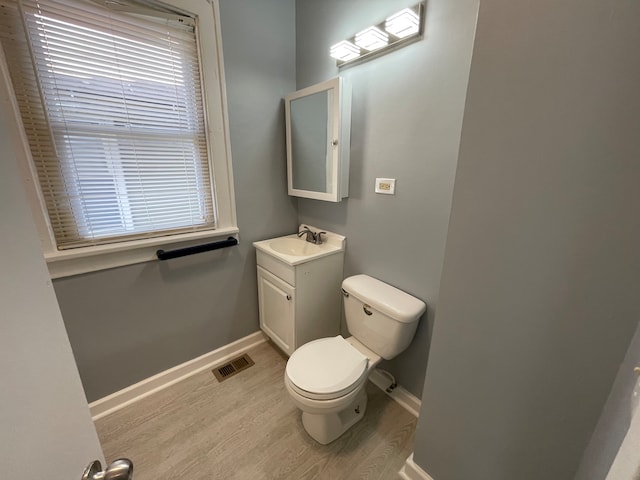 bathroom with wood-type flooring, toilet, and vanity