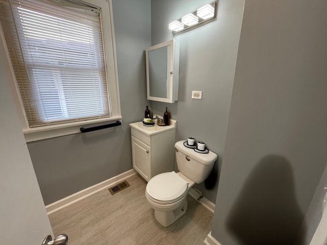 bathroom featuring vanity, toilet, a wealth of natural light, and hardwood / wood-style floors