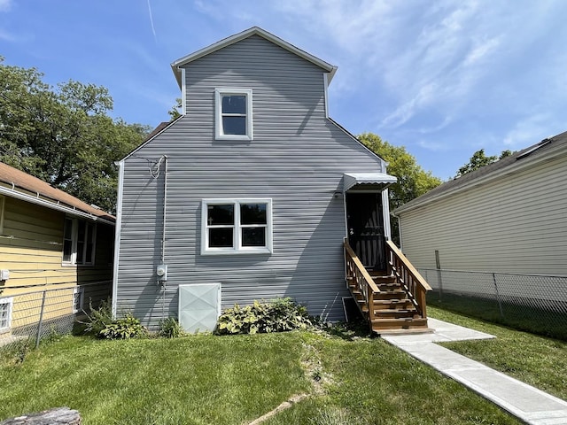 rear view of property with a yard and fence